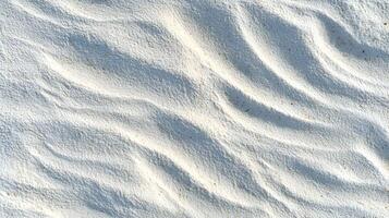 Serene ripples and gentle contours grace a pristine white beach creating a soft textured surface illuminated by sunlight photo