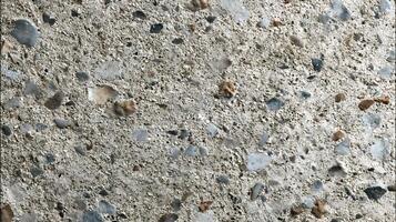 Close up view of concrete surface with pebble stones embedded gives a speckled pattern and texture photo
