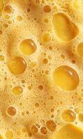 Abstract macro photograph showing a texture of golden beer foam with varied sized bubbles creating interesting shapes and forms photo