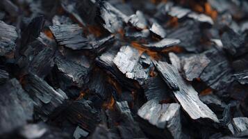 Burning embers glow softly beneath a pile of charcoal creating an intriguing abstract pattern photo