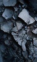 Cracked earth fragments showcase a dark gray abstract pattern with rough textures and sharp edges displaying natural decay photo