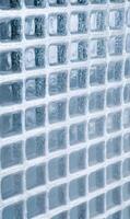 Abstract transparent glass block wall creating a modern texture and geometric pattern in blue tones showcasing interior design photo