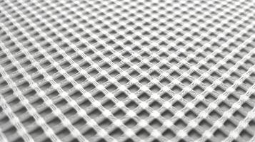 Close up perspective of a net like fabric with a white pattern against a neutral gray background photo