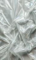 Crumpled shimmering plastic sheet with iridescent reflections abstract texture full frame close up background material photo