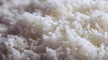 Close up of fluffy and freshly cooked white rice grains creating a textured background pattern photo