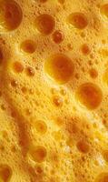 Captivating close up of a porous yellow sponge surface showcasing intricate details and textured patterns, creating an abstract visual feast photo