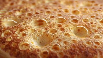 Close up of water drops on a porous surface shows unique texture and abstract design with golden highlights photo