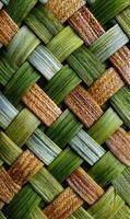 Detailed weaving pattern of green and brown strips creating a textured surface background design full frame photo
