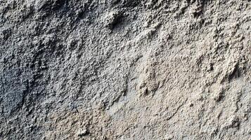 Textured surface featuring coarse aggregate and variations in color creates an abstract pattern photo