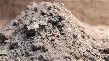 Pile of grainy earthy material resembling dry soil or sand in a close up studio shot photo