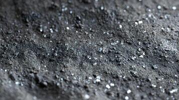 Close up of a rough dark textured surface with sparkling white crystals emphasizing depth and detail photo