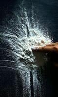 Creating flour art with a playful touch exploring textures and patterns with a single fingertip in a dark culinary space photo