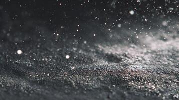 Abstract shimmering background with sparkling light reflecting from dark grainy material surface photo