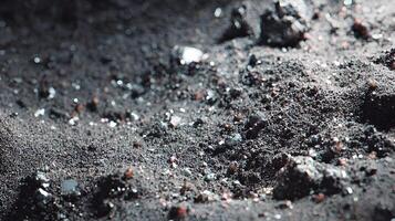 Close up of a textural landscape of dark sand and small rocks creating an interesting pattern photo