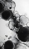 Monochrome abstract art showcasing ink droplets merging in a fluid pattern creating a mesmerizing effect photo