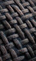 Intricate woven texture showing close up detail of a dark wicker or fabric background design pattern photo