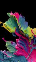 A vibrant explosion of multicolored paint suspended against a stark black backdrop creating dynamic energy and visual interest photo