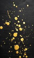 Gold splashes of abstract paint on black surface creating dynamic and artistic patterns of color and texture photo