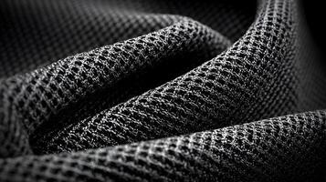 Close up of intricately woven black mesh fabric creating a textured and rhythmic abstract pattern photo