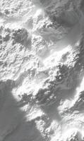 Aerial view of a rugged snowy mountain range bathed in sunlight casting shadows on the peaks landscape photo