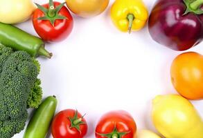 A circle of vegetables arranged around a white background photo