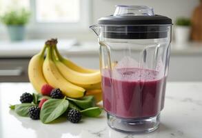 A blender with a banana, berries and a smoothie photo