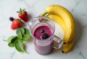 A blender with a smoothie in it next to bananas and berries photo