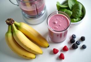 A blender with a banana, raspberries and a bowl of berries photo