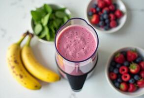 A blender with a smoothie in it and some fruit photo