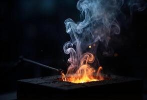 A blacksmith is using a torch to make a fire photo