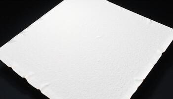 A white sheet of paper on a black surface photo