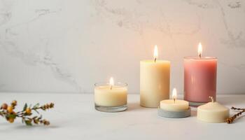 Burning candles in glass and stone holders with decorative plant on marble surface photo