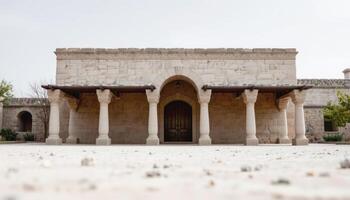 Ancient stone building facade with columns and arched doorway under cloudy sky photo