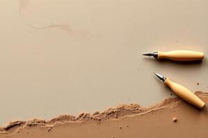 Calligraphy pen nibs with wooden handles on brown and beige background with textured clay edge photo