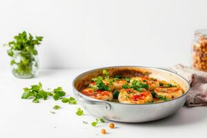 Grilled cheese rounds with herbs in pan on white surface creating fresh cooking scene photo