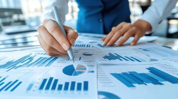 Analyzing Data Hand with Pen Over Charts - Strategic Planning and Financial Analysis Focus photo