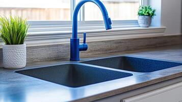 Modern Kitchen Sink with Bold Blue Faucet Greenery accents under Window Light photo