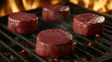 Sizzling Steaks Four Filet Mignons on a Charcoal Grill Over Fiery Embers photo