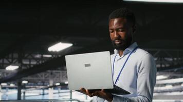 Technicians on data center industrial platform analyzing performance outputs after completing software updates. Server hub engineering team finetuning server rig configurations, camera B video