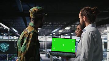 Army engineering team in command center server hub using mockup laptop to install and maintain IT systems. Military data center admins overseeing information systems with chroma key notebook, camera A video