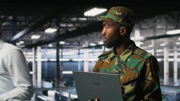 Army IT specialist in data center using laptop to defend networks against cyber threats. Military command center admin using notebook to identify potential intrusions or malicious activities, camera B video