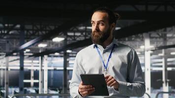 Technicians on data center platform using devices to monitor neural network LLM visualization. Industrial server hub engineering team overseeing rigs powering machine learning processes, camera B video