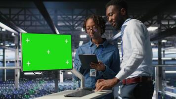 Data center engineering team coding on green screen PC, monitoring AI systems. Server hub IT coworkers use mockup computer to oversee rackmounts powering deep learning processes, camera B video