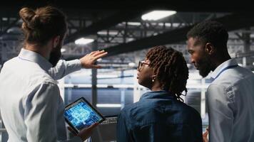 Software developers in data center monitoring AI LLM visualization. Server farm teamworking colleagues doing brainstorming, overseeing rigs powering machine learning processes, camera B video