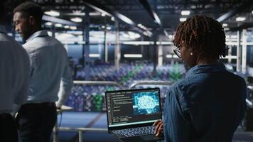 Data center coworkers doing maintenance on mainframes handling AI processing tasks. Server hub system administrators managing storage arrays supporting deep learning training workflows, camera A video