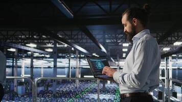 Server farm IT expert managing storage arrays supporting machine learning training workflows. Technician on industrial platform doing maintenance on rigs handling AI processing tasks, camera A video