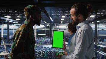 Military personnel overseeing AI computing operations on isolated screen tablet in high tech server facility. Army tech experts using chroma key device to oversee communication systems, camera A video