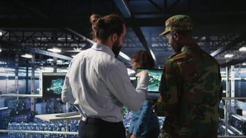 Army operators in data center using laptop to run drone control software, looking at mission map overlay. Military experts doing strategic deployment of autonomous aerial vehicles, camera A video