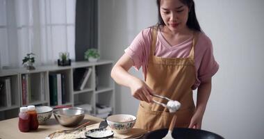 Handheld shot, A beautiful woman is mixing chicken wings with fried flour to prepare for frying. Woman cooking at home. Food preparation. video