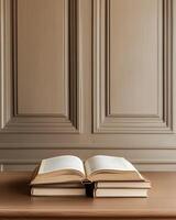 Open Book and Stack of Books on Wooden Table Against Paneled Wall photo